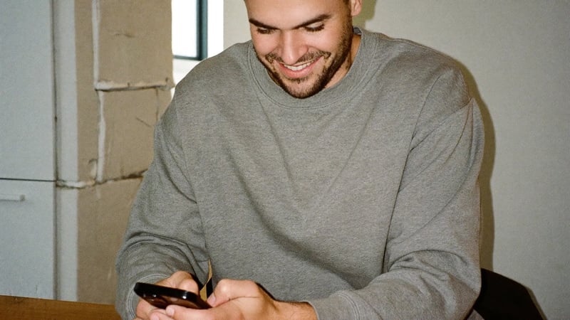 Man reviewing his Hinge prompt answers on his phone before updating his profile