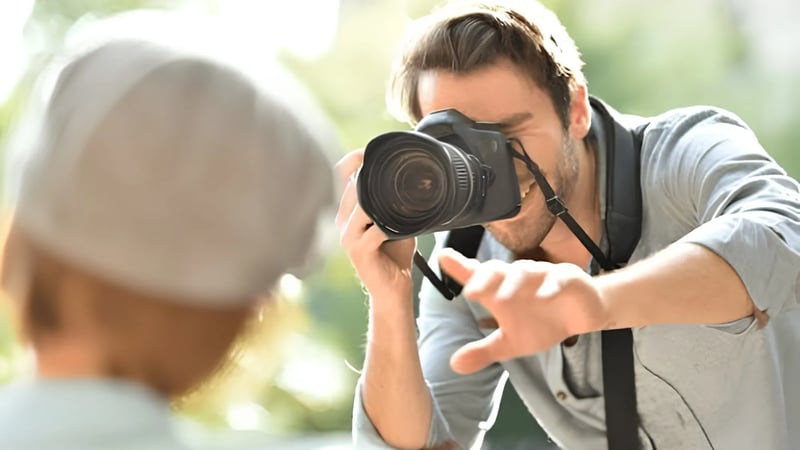Professional dating photographer directing a man during an outdoor photo session showing expression coaching and body language guidance